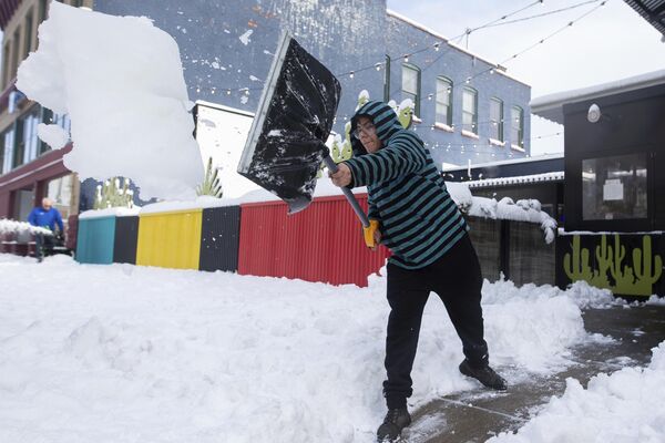 2022年11月18日，21岁的乔纳森·卡梅纳蒂在纽约州布法罗清除人行道上的积雪。暴风雪导致纽约部分地区瘫痪，积雪深度近2英尺。 - 俄罗斯卫星通讯社