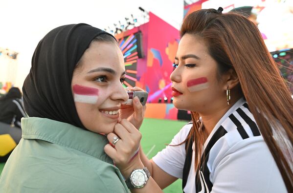 卡塔尔世界杯上女球迷正在往脸上涂抹卡塔尔国旗的标志性颜色。 - 俄罗斯卫星通讯社