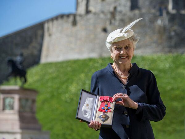 2014年4月15日，英国女演员安吉拉·兰斯伯里在伯克郡温莎城堡被英国女王授予大英帝国子爵级司令勋章后合影。 - 俄罗斯卫星通讯社