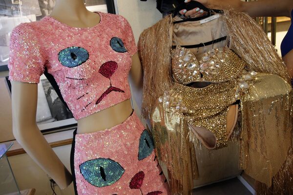 左边是凯蒂·佩里在2014年MTV欧洲音乐大奖上穿的一件粉色亮片的猫形象上衣和裙子；右边是妮基·米娜在pink print巡回演唱会舞台上穿的定制金色服装，2017年7月19日。 - 俄罗斯卫星通讯社