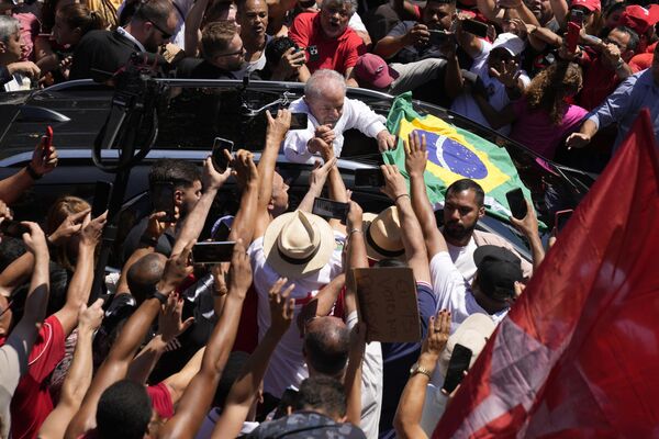 2022年10月30日，巴西前總統路易斯·盧拉·達席爾瓦（中）再次競選總統。他在巴西聖保羅舉行的大選投票後與一名支持者握手。 - 俄羅斯衛星通訊社