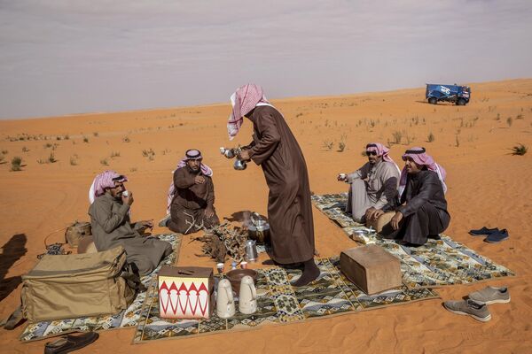 沙特阿拉伯居民在沙丘上邊喝茶邊看達喀爾汽車拉力賽。 - 俄羅斯衛星通訊社