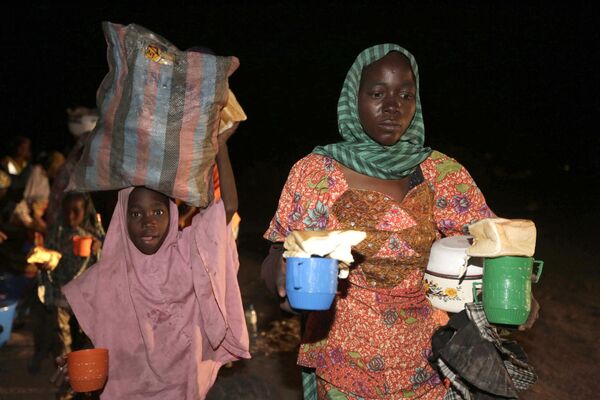 一名妇女和儿童与其他人一起在尼日利亚尤拉难民营领取茶叶面包。 - 俄罗斯卫星通讯社