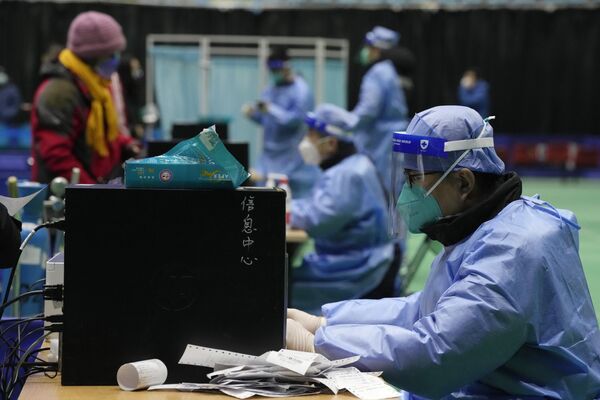 2022年12月17日，北京，在一个由体育馆改建的发热诊所里，医务人员在接待病人。 - 俄罗斯卫星通讯社