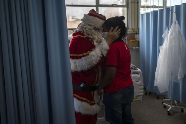 身著聖誕老人服飾的社會義工在里約熱內盧市兒科重症病房擁抱患者母親。 - 俄羅斯衛星通訊社