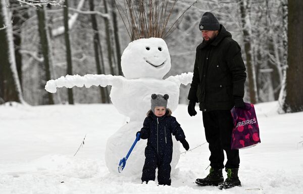 莫斯科河運碼頭地鐵站附近，一名父親帶著孩子在友誼公園裡堆雪人。 - 俄羅斯衛星通訊社