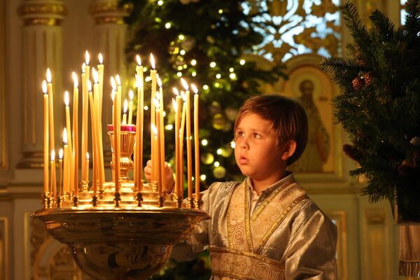 小男孩在阿聯酋沙迦東正教教堂中點明蠟燭。 - 俄羅斯衛星通訊社