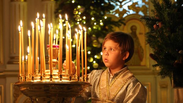 小男孩在阿聯酋沙迦東正教教堂中點明蠟燭。 - 俄羅斯衛星通訊社