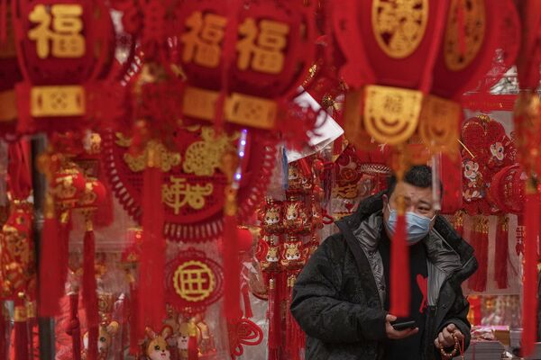 1月7日,中国一名戴着口罩的男子在北京一家街边商店购买农历新年装饰品。 1月7日,中国一名戴着口罩的男子在北京一家街边商店购买农历新年装饰品。 - 俄罗斯卫星通讯社