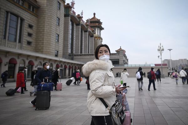 1月7日,中国一名女子在北京火车站入口的路上回头张望。中国一年一度春运已经开始。 1月7日,中国一名女子在北京火车站入口的路上回头张望。中国一年一度春运已经开始。 - 俄罗斯卫星通讯社