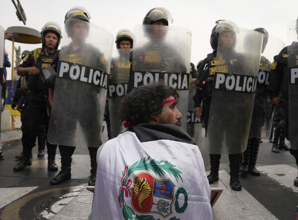 秘鲁利马，一名男子参加反对秘鲁总统博卢阿特的游行活动时，坐在警察队列的前面。 - 俄罗斯卫星通讯社