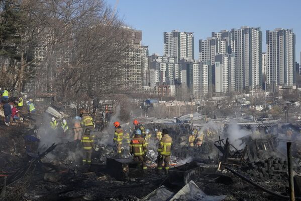 韓國首爾貧民窟九龍村的大火被撲滅後，消防員和救援人員站在瓦礫堆上。 - 俄羅斯衛星通訊社