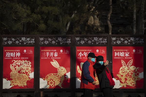 1月22日，农历大年初一，星期日，在北京一个公园里，戴着口罩的游客在一排以兔年为主题的广告牌前拍照。 - 俄罗斯卫星通讯社