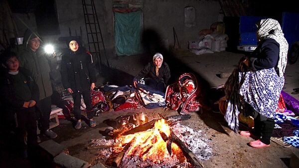 伊朗西北部城市霍伊發生地震後，人們圍坐在篝火旁。  - 俄羅斯衛星通訊社