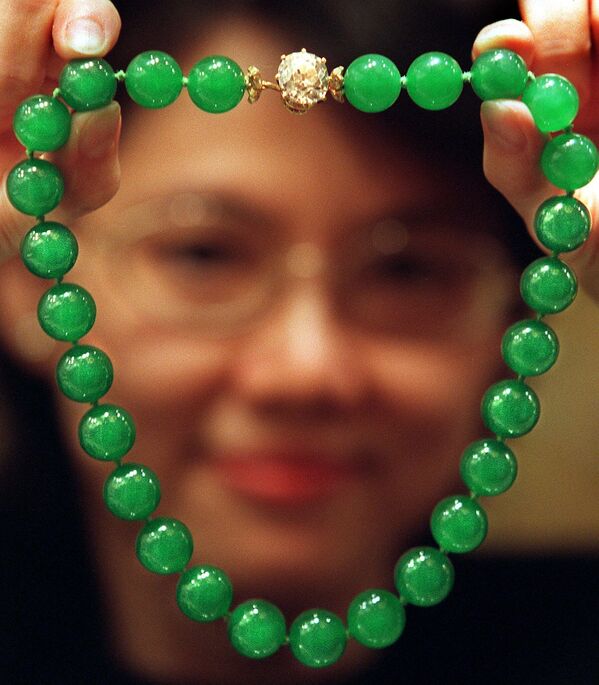 一位寶石專家展示了香港佳士得“Doubly Fortunate”翡翠項鍊。它被認為是有史以來出現在拍賣會上的最重要的翡翠珠寶。(照片：STEPHEN SHAVER / AFP) - 俄羅斯衛星通訊社