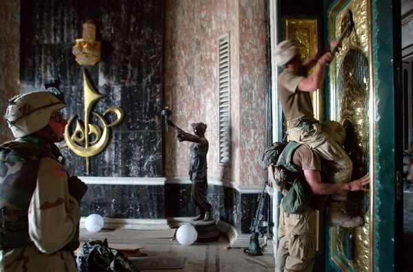2003 年，伊拉克巴格达，一美军士兵正在撕萨达姆•侯赛因总统府正门上金制装饰物。 - 俄罗斯卫星通讯社