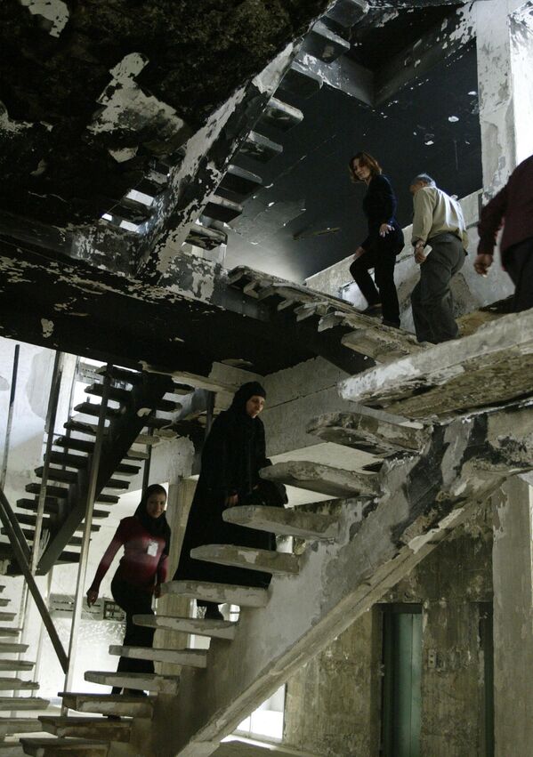 2004 年，巴格達穆薩納圖書館員工正在館中被燒毀和搶劫的建築部分爬樓梯。 - 俄羅斯衛星通訊社