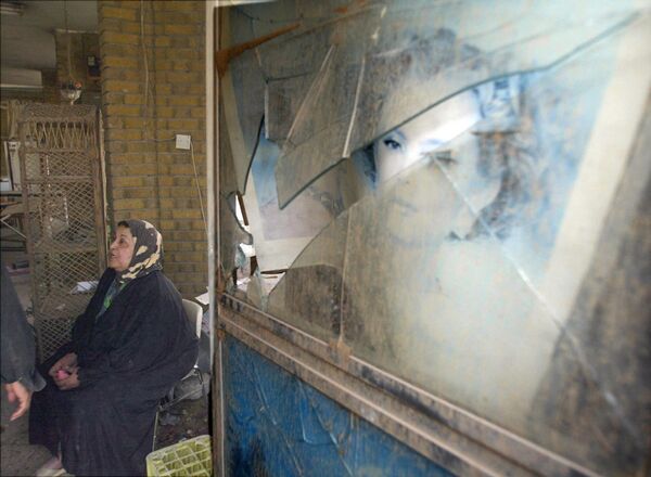 伊拉克，一店主正坐在她被美軍夜間轟炸後受損的商店前。 - 俄羅斯衛星通訊社