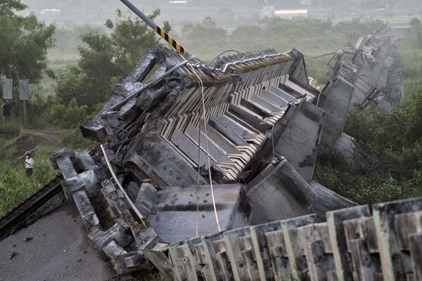 2022年9月，台灣東部地震後，一名記者在一座倒塌的橋梁旁走過 - 俄羅斯衛星通訊社
