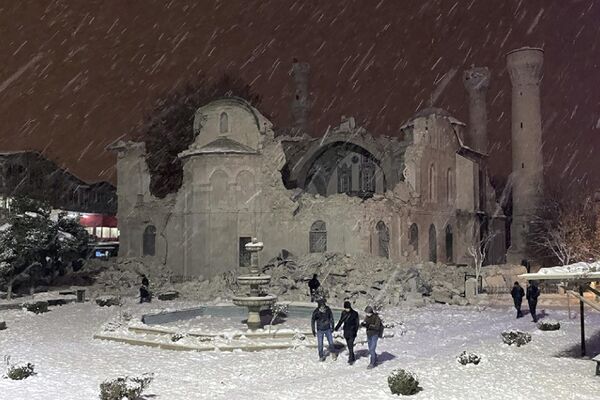 2023年2月6日，土耳其馬拉蒂亞省，人們走在被地震摧毀的清真寺旁。土耳其東南部和敘利亞發生強震，多座建築被震塌，造成多人傷亡。(圖片來源：美聯社通過美國國防情報局提供) - 俄羅斯衛星通訊社