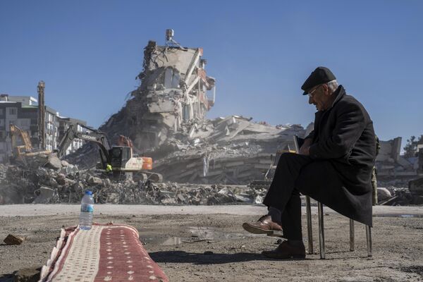 2023年2月9日，土耳其东南部的努尔达伊，67岁的穆罕默德·纳西尔·杜兰坐在椅子上，重型机器正在清除一栋大楼的瓦砾，他的五名家人被困在那里。 - 俄罗斯卫星通讯社