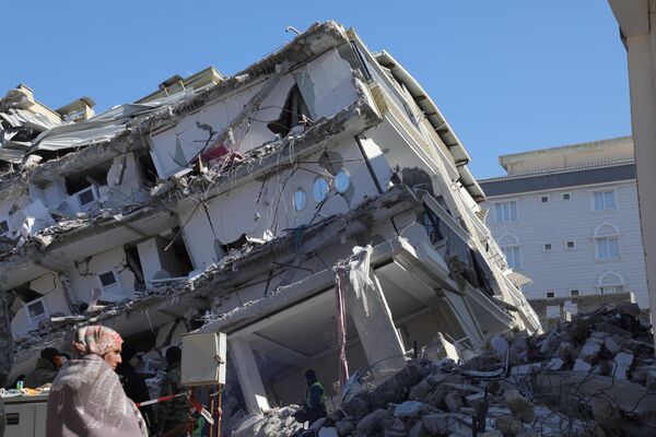 一名女子站在伊斯拉希耶鎮上被毀的建築前，伊斯拉希耶位於土耳其和敘利亞邊境受災嚴重的加濟安泰普地區 - 俄羅斯衛星通訊社
