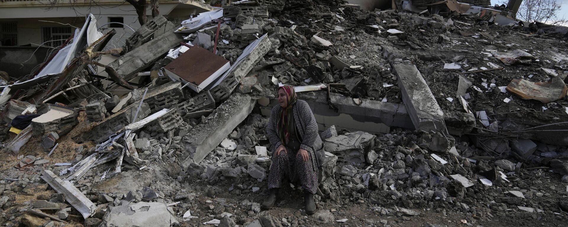 土耳其南部城市努爾達伊，一名婦女坐在廢墟上的同時，救援人員在廢墟下尋找幸存者 - 俄羅斯衛星通訊社, 1920, 21.02.2023