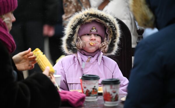 谢肉节期间，一名女孩在莫斯科革命广场上吃煎饼。 - 俄罗斯卫星通讯社
