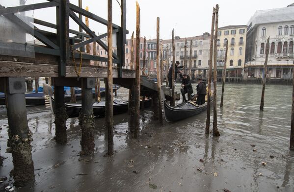 威尼斯，人們從貢多拉船上下來，船隻因河道乾涸停泊在碼頭附近 - 俄羅斯衛星通訊社