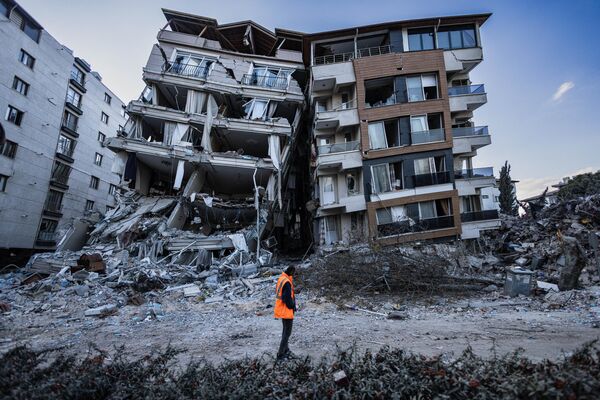 土耳其安塔基亞，救援人員經過局部被地震摧毀的建築物 - 俄羅斯衛星通訊社