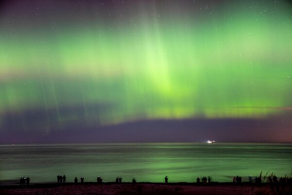 2023年2月27日，游客在丹麦hornbaek海滩散步，北极光照亮了天空。 - 俄罗斯卫星通讯社
