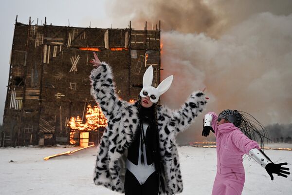 俄羅斯卡盧加州Nikola-Lenivets藝術公園的謝肉節慶祝活動參觀者。這裡正在焚燒由回收材料組裝的19米長的立方體藝術品“第四面牆”。 - 俄羅斯衛星通訊社