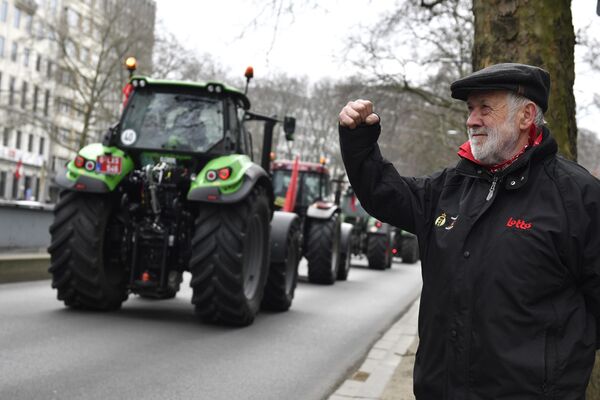 一名男子站在路邊支持舉行示威遊行的農民們。比利時農民在布魯塞爾舉行示威遊行，抗議政府關於農業和畜牧業氮肥使用和氮排放的限制政策 - 俄羅斯衛星通訊社