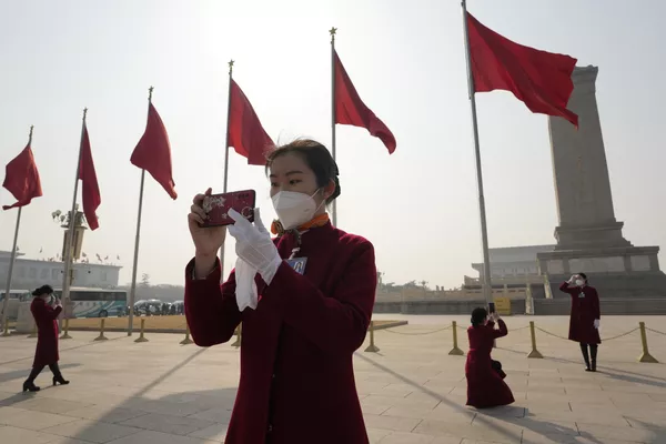 3月4日，中国天下国夷易近代表大会揭幕前夜，两会巴士女乘务员在天安门广场摄影。 - 俄罗斯卫星通信社