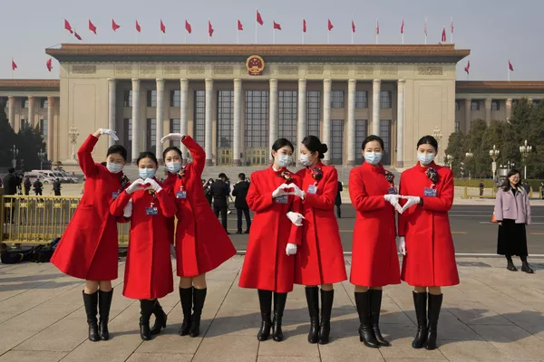 3月4日，中国天下国夷易近代表大会揭幕前夜，两会大巴女乘务员在国夷易近大礼堂外摄影。 - 俄罗斯卫星通信社