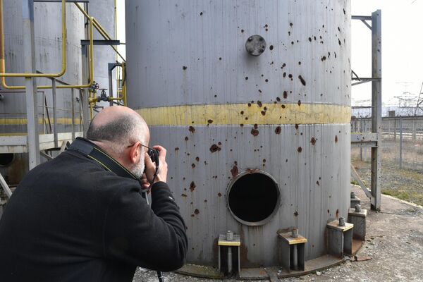 一名記者在拍攝扎波羅熱核電站的炮擊破壞情況。 - 俄羅斯衛星通訊社