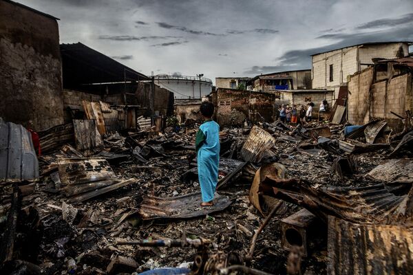 2023年3月4日，雅加達北部的一個住宅區，一名男孩站在被火災燒毀的房屋殘骸中。(照片：ADITYA AJI / AFP) - 俄羅斯衛星通訊社