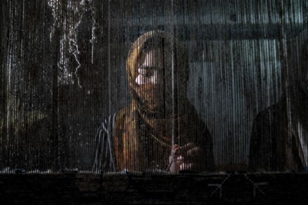 2023年3月6日，一名阿富汗妇女在喀布尔的一家传统地毯厂编织地毯。塔利班上台后，妇女被剥夺了许多基本权利。 - 俄罗斯卫星通讯社