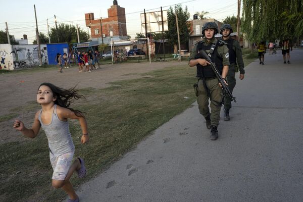 2023年3月9日，阿根廷羅薩里奧，一名女孩在邊防警察巡邏時奔跑。周日早些時候，至少一名持槍者襲擊一個生日派對，11歲男孩Maximo Jerez被殺害。(照片：AP Photo/Rodrigo Abd) - 俄羅斯衛星通訊社