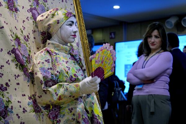 在黎巴嫩貝魯特舉行的阿拉伯可持續發展論壇上，一名女性參觀者正在看一位女子，該女子是互動藝術作品的一部分 - 俄羅斯衛星通訊社