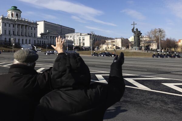3月21日，人們揮手歡迎習近平的車隊駛向克里姆林宮。車隊正經過弗拉基米爾大公雕像。 - 俄羅斯衛星通訊社