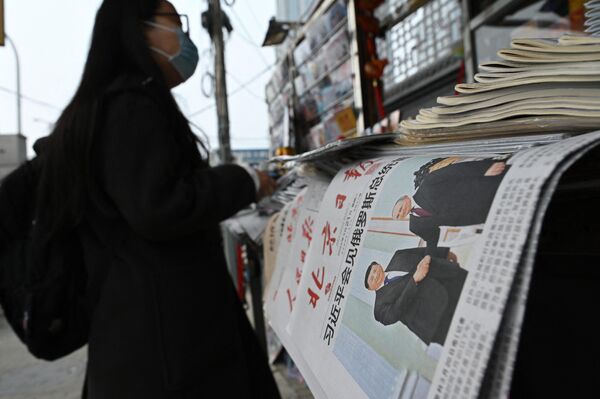 3月21日，在北京一個報刊攤前，一名女子站在刊登著習近平在莫斯科會見普京作為頭版照片的報紙旁。 - 俄羅斯衛星通訊社