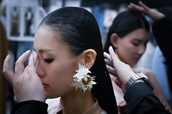 2023年3月24日，在北京舉行的中國時裝周開幕式上，一名模特在後台準備展示作品。 - 俄羅斯衛星通訊社