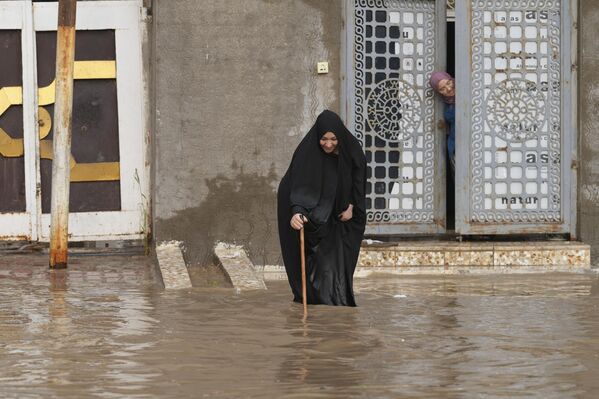 一名伊拉克婦女在被洪水淹沒的納傑夫市街道上行走。 - 俄羅斯衛星通訊社