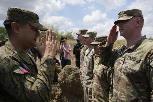 在菲律宾进行的美菲SALAKNIB联合军演中，菲律宾陆军炮兵团团长安东尼·科罗内尔（左）回应美国士兵的问候。 - 俄罗斯卫星通讯社