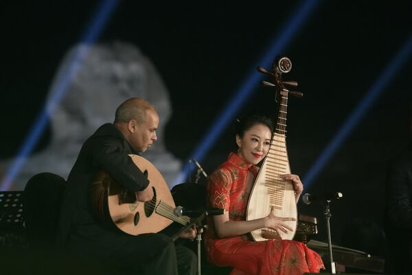 2023年4月3日，开罗吉萨金字塔古迹前，一名埃及乐手和一名中国乐手用传统的奥德琴和琵琶共同演奏。(照片：AP Photo/Amr Nabil) - 俄罗斯卫星通讯社