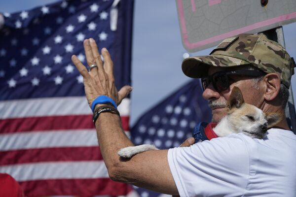 2023年4月4日，佛罗里达州西棕榈滩，特朗普的支持者乔·冈萨雷斯与他的狗Asti一起参加集会。 - 俄罗斯卫星通讯社