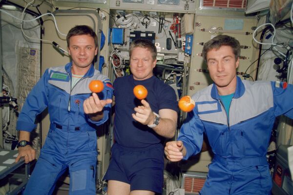 “遠徵1號”(Expedition-1)乘組人員正在國際空間站星辰號服務艙里吃新鮮水果。圖中從左到右分別為俄羅斯航天員、聯盟號指揮官尤里·吉德津科，美國宇航員、指令長威廉·謝潑德和俄航天員、航天工程師謝爾蓋·克里卡列夫。 - 俄羅斯衛星通訊社