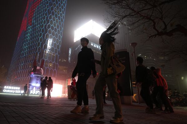 2023年4月10日，沙塵暴席捲北京，街上的行人。(照片：AP /Ng Han Guan) - 俄羅斯衛星通訊社