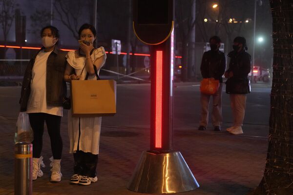 2023年4月10日，沙塵暴席捲北京，一名女性用手帕捂住嘴。(照片：AP/Ng Han Guan) - 俄羅斯衛星通訊社